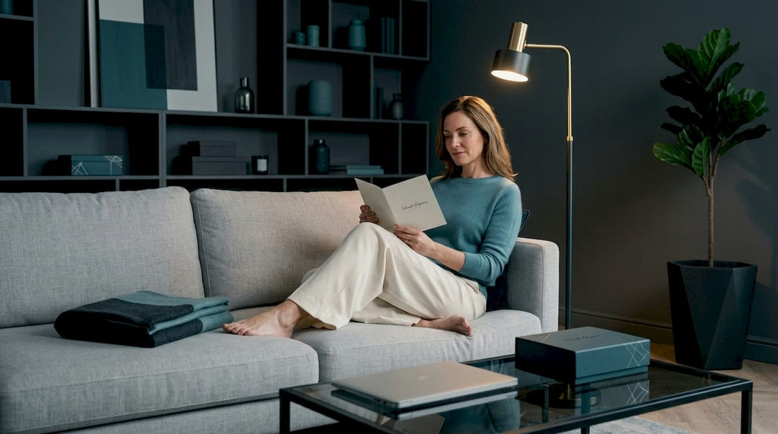 Woman reading booklet on sofa with discreet product box