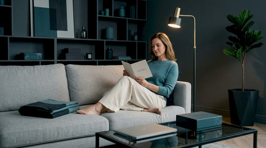 Woman reading booklet on sofa with discreet product box