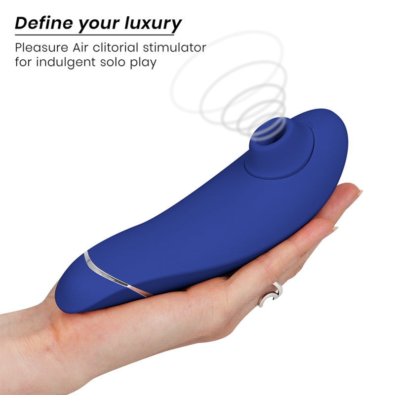Blueberry-colored Womanizer Premium 2 clitoral stimulator held in hand with spiral airflow graphic.