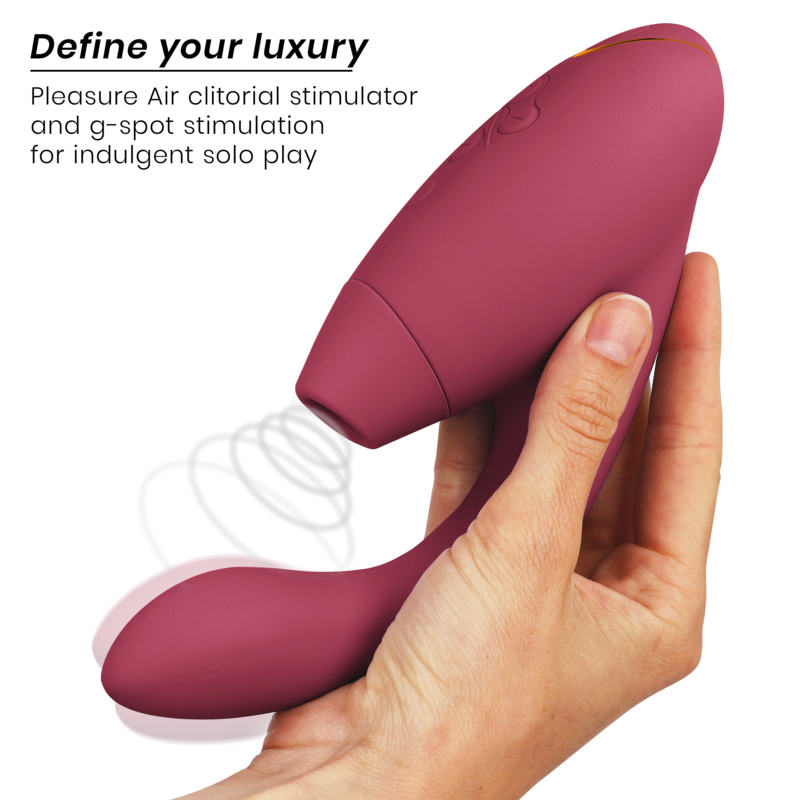 Bordeaux silicone dual stimulator with ergonomic curved design held in hand.