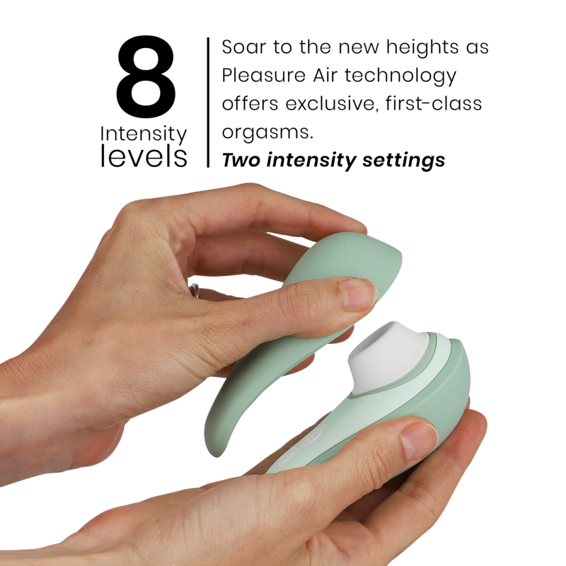 Light green Womanizer Liberty 2 clitoris stimulator with ergonomic shape held in two hands.