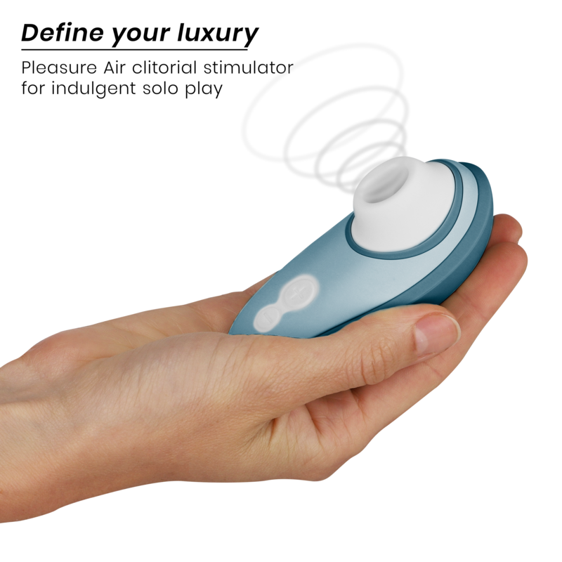 Compact blue and white clitoris stimulator with ergonomic shape held in hand.