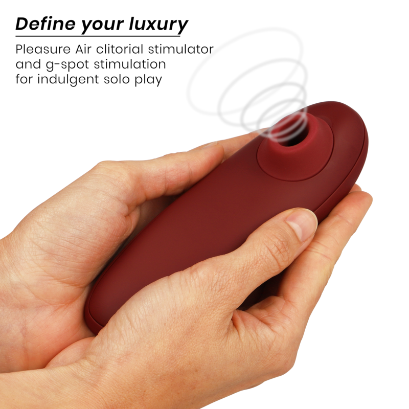 Bordeaux Womanizer Classic 2 clitoral stimulator held in hand with curved ergonomic design.