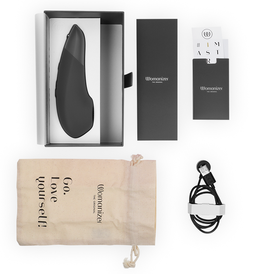 Black Womanizer Enhance clitoral stimulator with packaging, drawstring pouch, and USB charging cable.