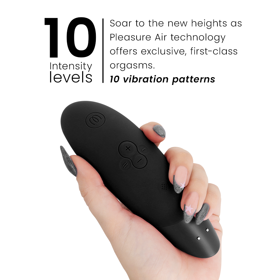Black ergonomic clitoral stimulator with plus, minus, and power buttons held in hand.