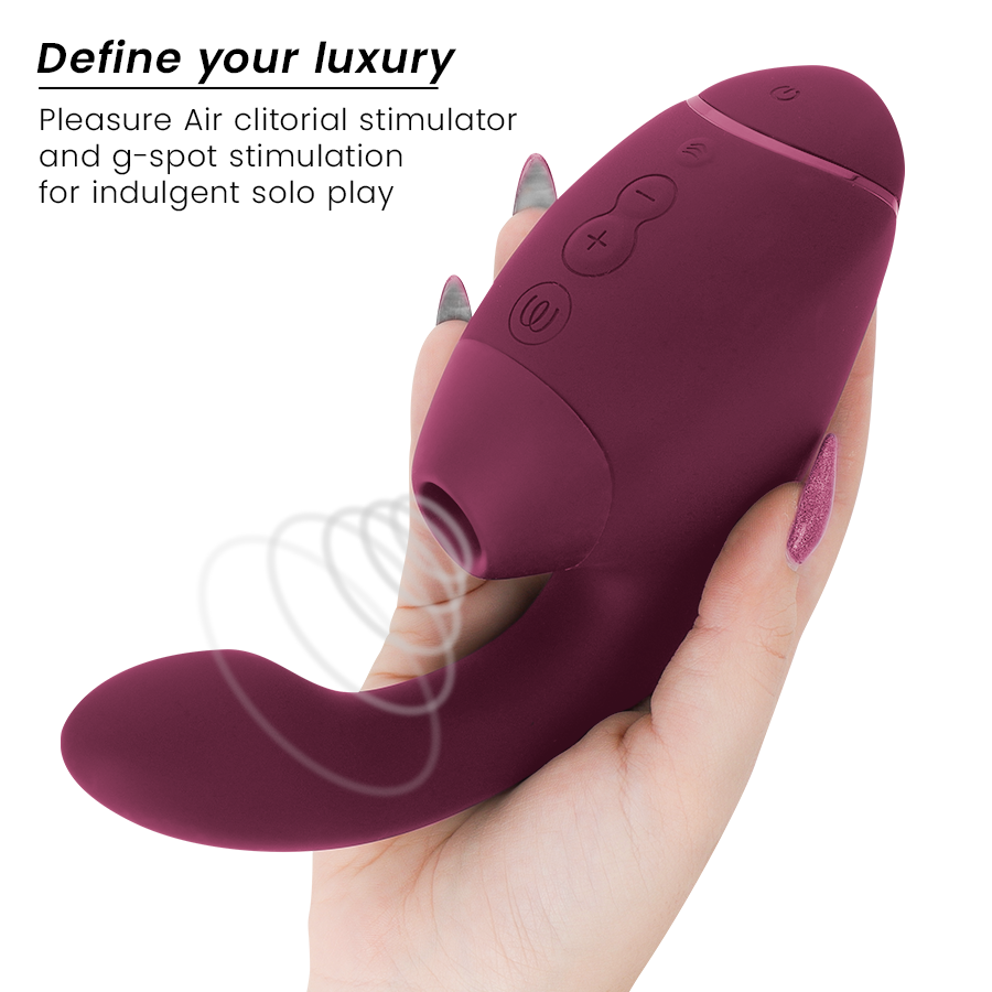 Dusky pink dual clitoral and G-spot stimulator with ergonomic shape and control buttons held in hand.