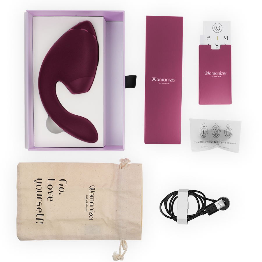 Dusky pink dual clitoral and G-spot stimulator with USB charger, storage pouch, and instruction booklet in purple box.