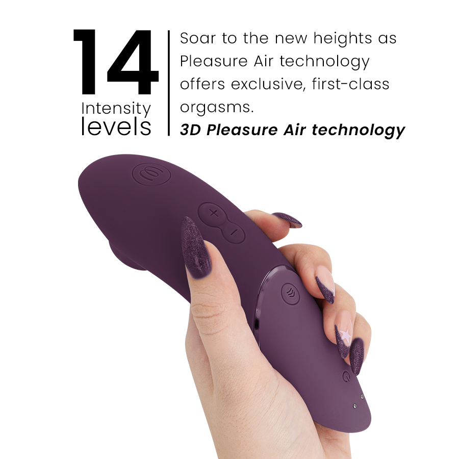 Dark purple Womanizer Next clitoral stimulator held in hand with three control buttons visible.