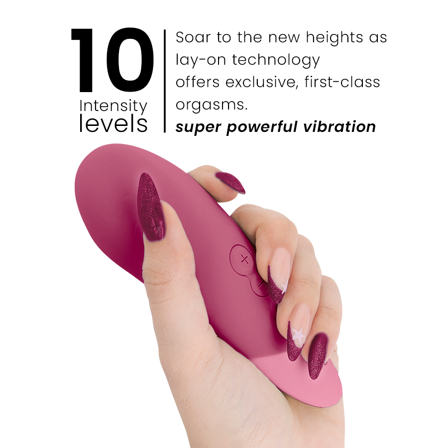 Dusky pink Womanizer Vibe lay-on vibrator with curved tip held by hand with manicured nails.
