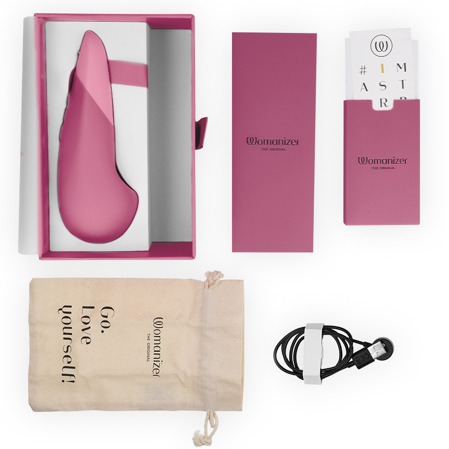 Dusky pink silicone vibrator with sleek ergonomic design in open box, branded packaging, drawstring pouch, and USB charging.