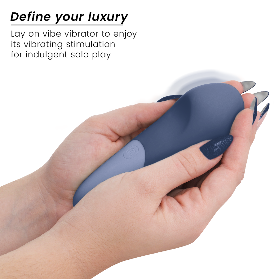 Dark blue compact lay-on vibrator held in hands with smooth matte finish and single button control.